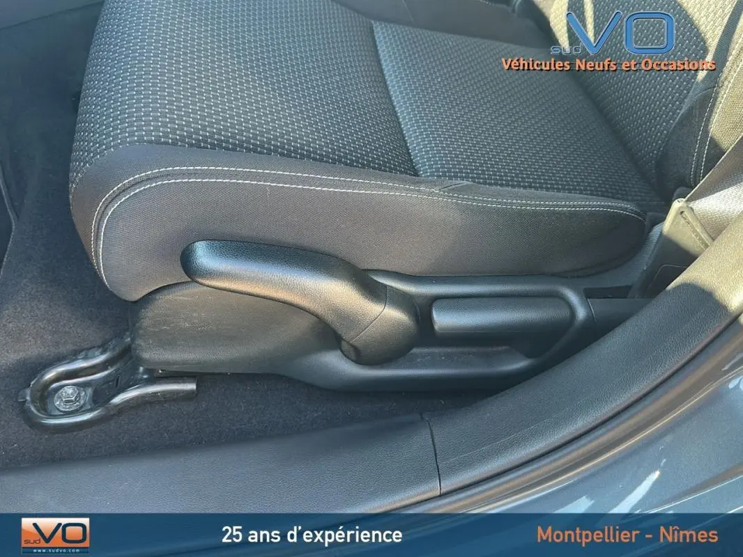 Gros plan sur la commande de réglage manuel du siège avant droit d'une Honda Civic gris 2015, tissu noir à surpiqûres blanches.