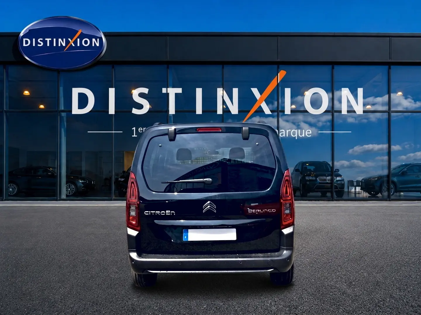 Vue arrière d’un Citroën Berlingo noir 2026 garé devant une vitrine avec logo Distinxion.