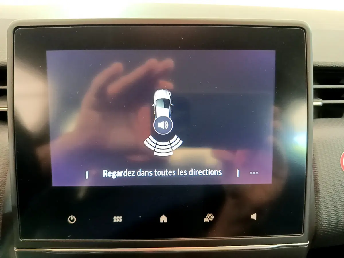 Écran tactile central affichant l'alerte de capteurs de distance sur Renault Clio Business blanc, vue intérieure frontale.