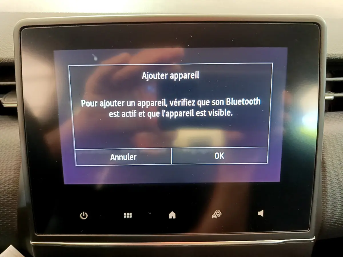 Écran tactile central de la Renault Clio Business blanc, affichant l'option d'ajout d'appareil Bluetooth.
