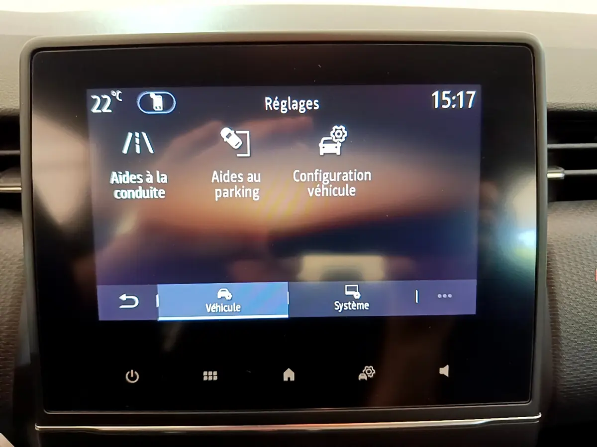 Écran tactile central de la Renault Clio Business blanc 2021 affichant les réglages d'aides à la conduite et parking.