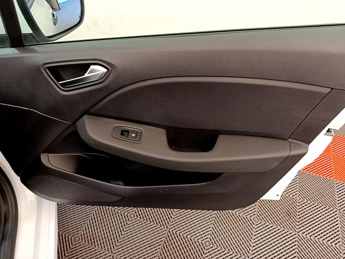 Intérieur côté gauche de la porte avant d'une Renault Clio Business blanche, avec panneau noir et commande de vitre.