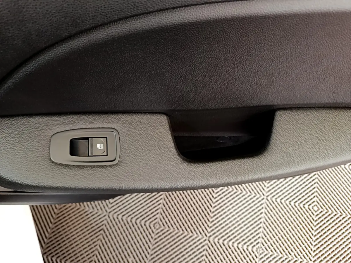 Bouton de verrouillage de porte sur la garniture intérieure côté gauche d'une Renault Clio Business blanche 2021.