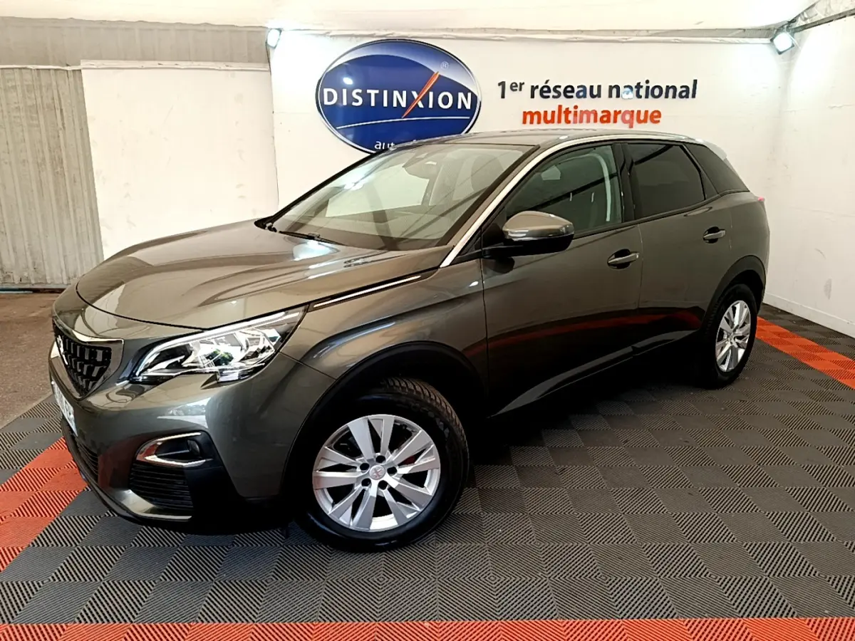 Peugeot 3008 gris foncé vue en 3/4 avant droit dans un showroom avec sol à damier noir et rouge.