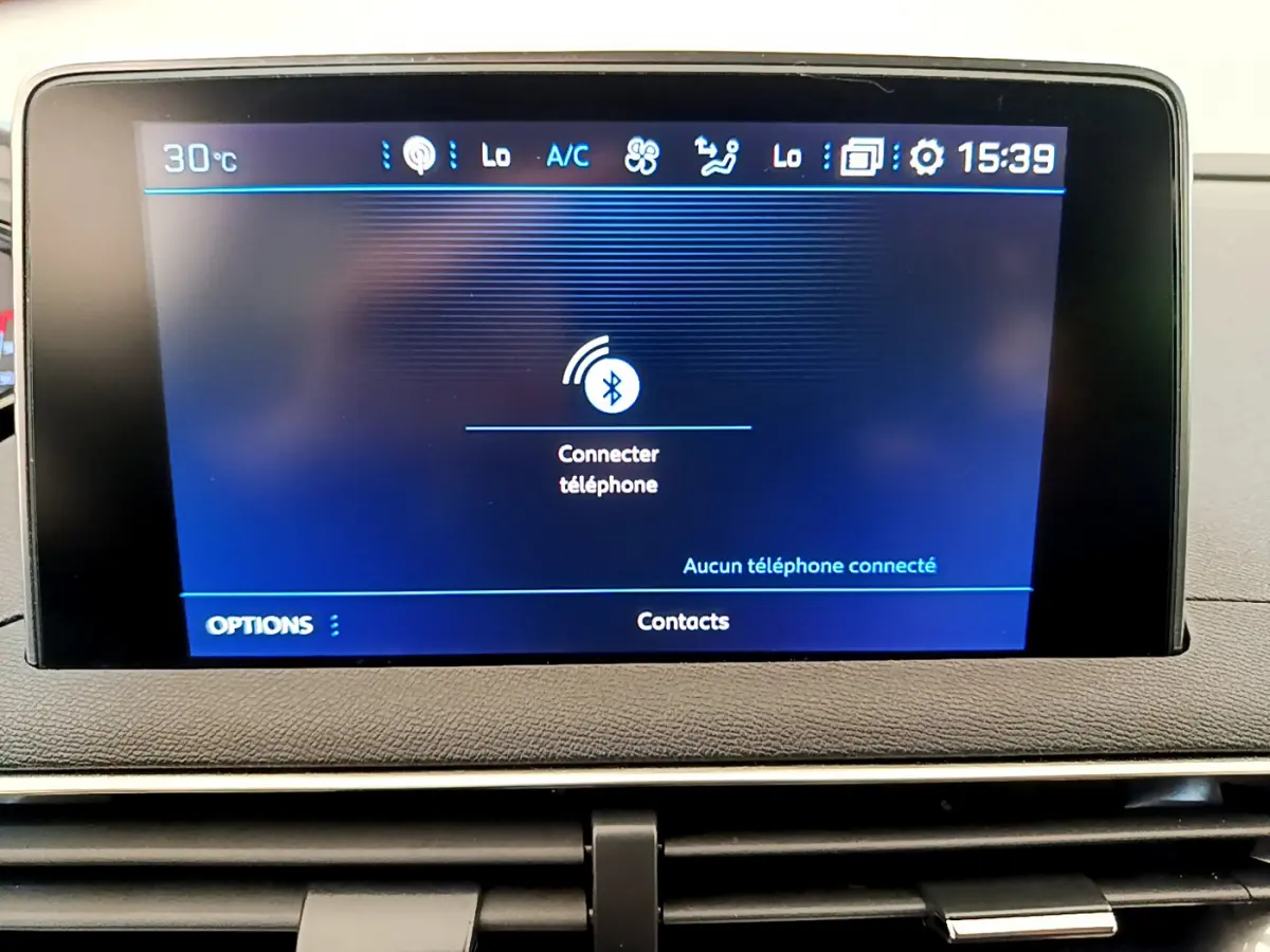 Écran tactile central du tableau de bord du Peugeot 3008 gris foncé, affichant la connexion Bluetooth téléphone.