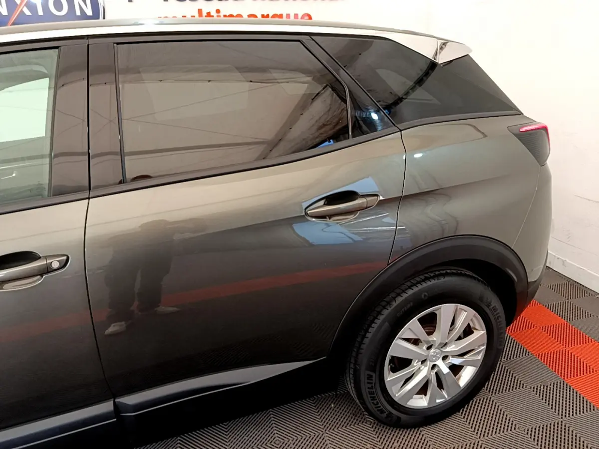 Vue latérale côté droit sur l'arrière d'un Peugeot 3008 gris foncé avec jante alliage et vitres teintées.