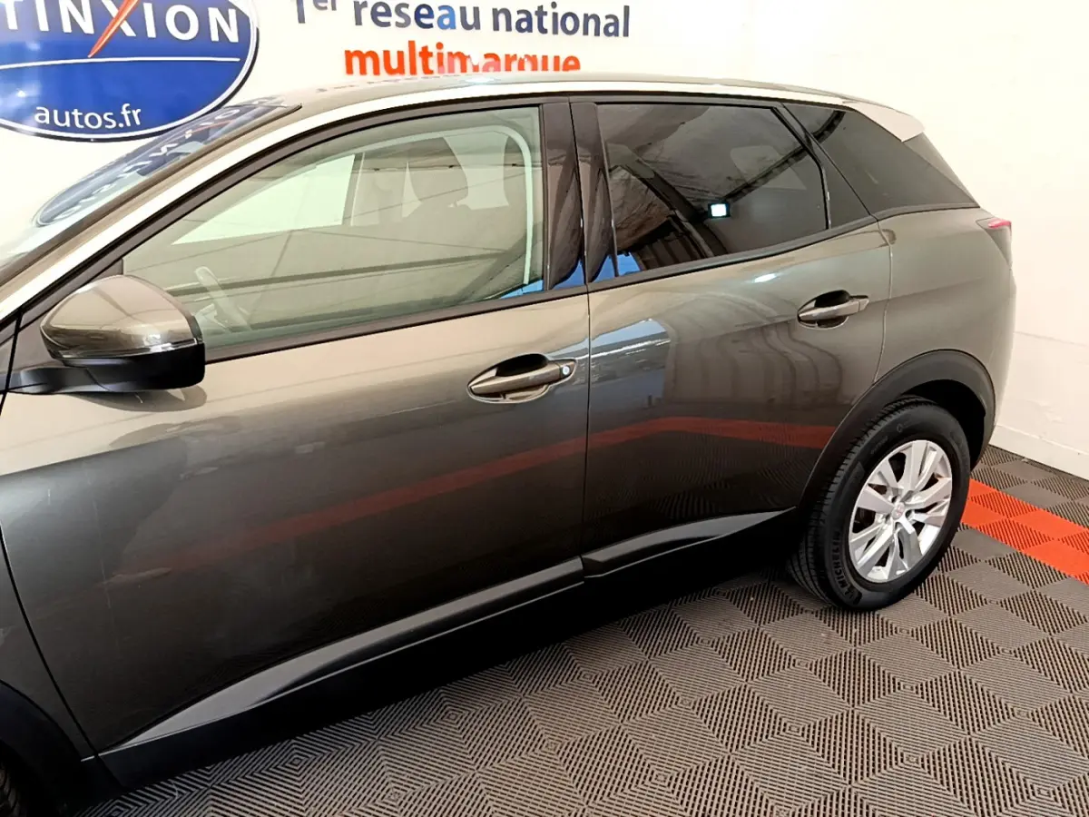 Vue latérale côté gauche du Peugeot 3008 gris foncé, mettant en valeur les lignes épurées et les jantes alliage.
