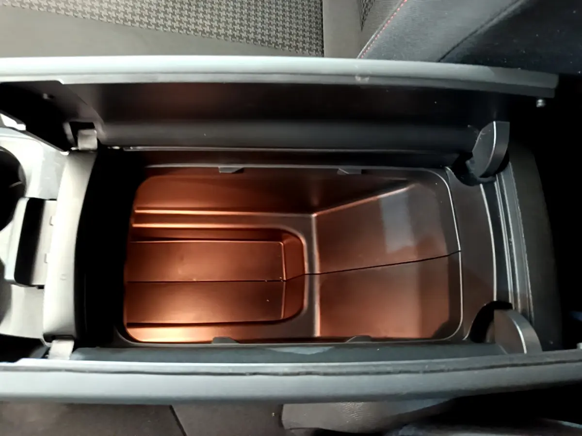 Vue plongeante sur le rangement réfrigéré noir dans l'accoudoir central du Peugeot 3008 gris foncé Puretech 130 S&S Active.