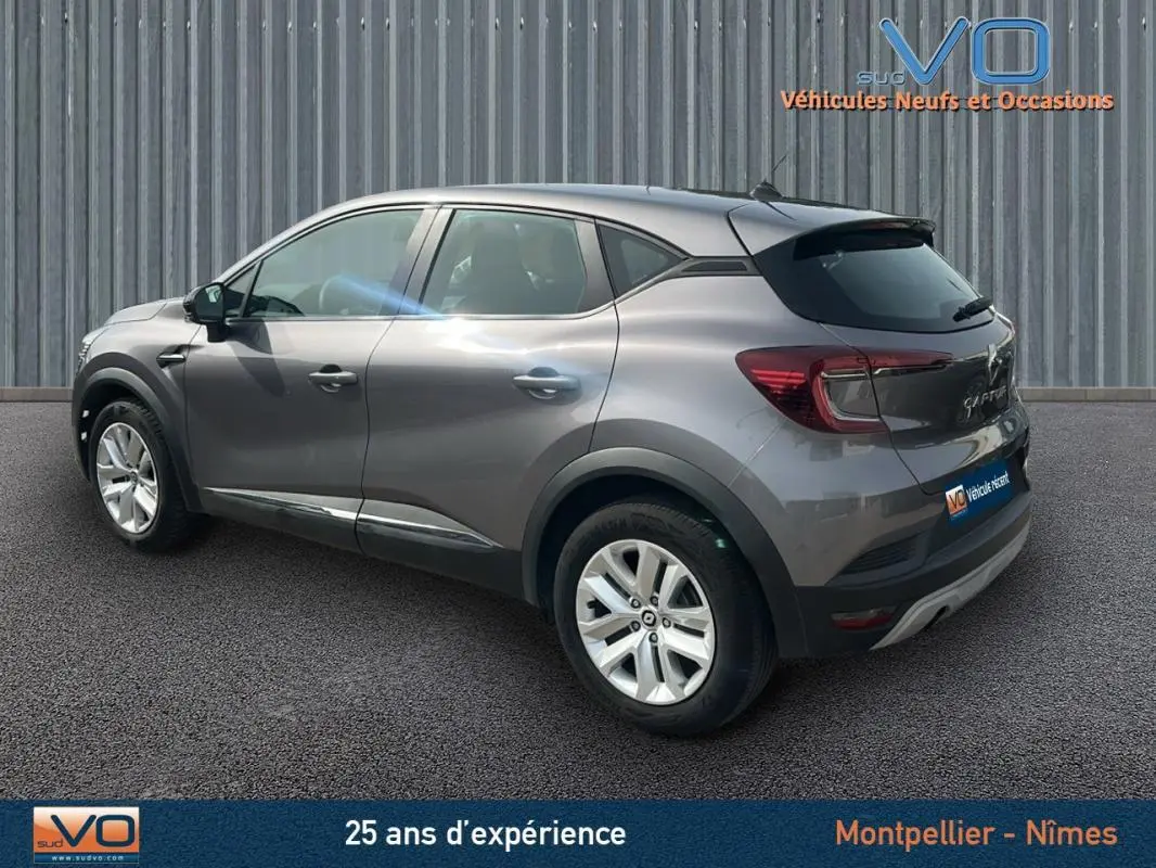 Renault Captur TCe 100 Business gris vu en 3/4 arrière droit, soulignant ses lignes modernes et ses jantes alliage.