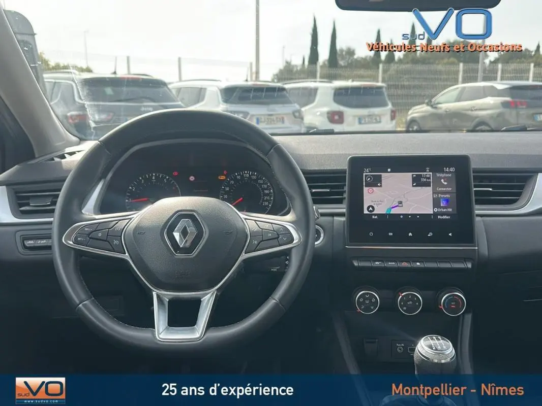 Vue intérieure du tableau de bord du Renault Captur gris 2020 avec volant multifonction et écran tactile central.