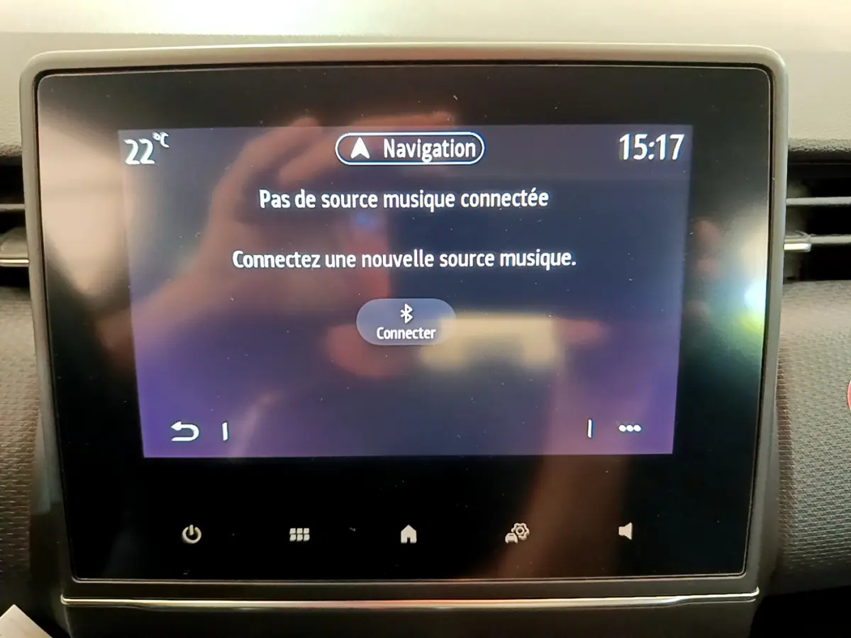 Écran tactile central de la Renault Clio Business blanc 2021 affichant un message de connexion Bluetooth pour la musique.