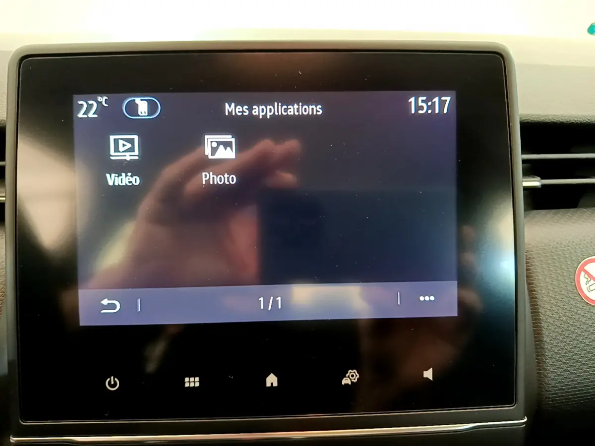 Écran tactile central de la Renault Clio Business blanc, affichant les applications vidéo et photo en intérieur.