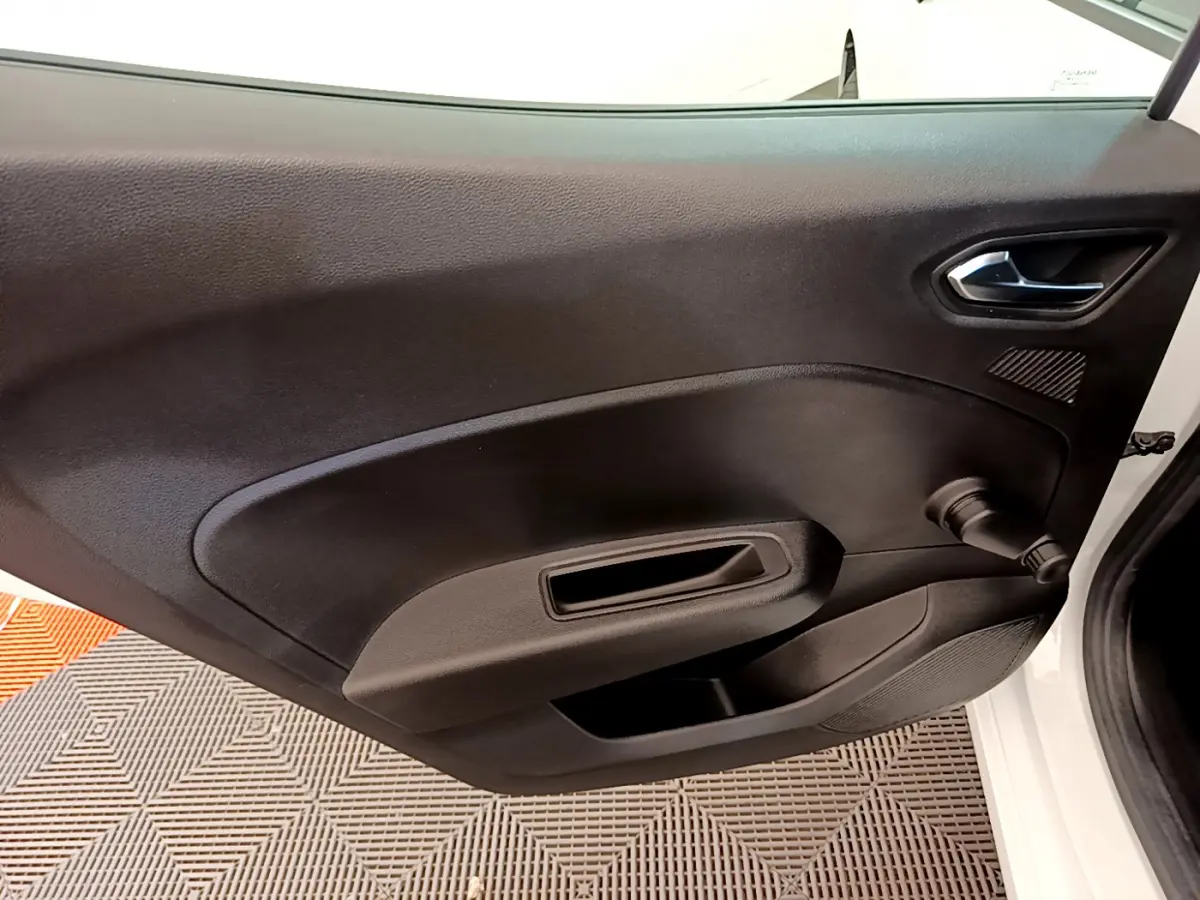 Vue rapprochée de la porte avant droite noire de la Renault Clio Business blanche, avec poignée et manivelle de vitre visible.