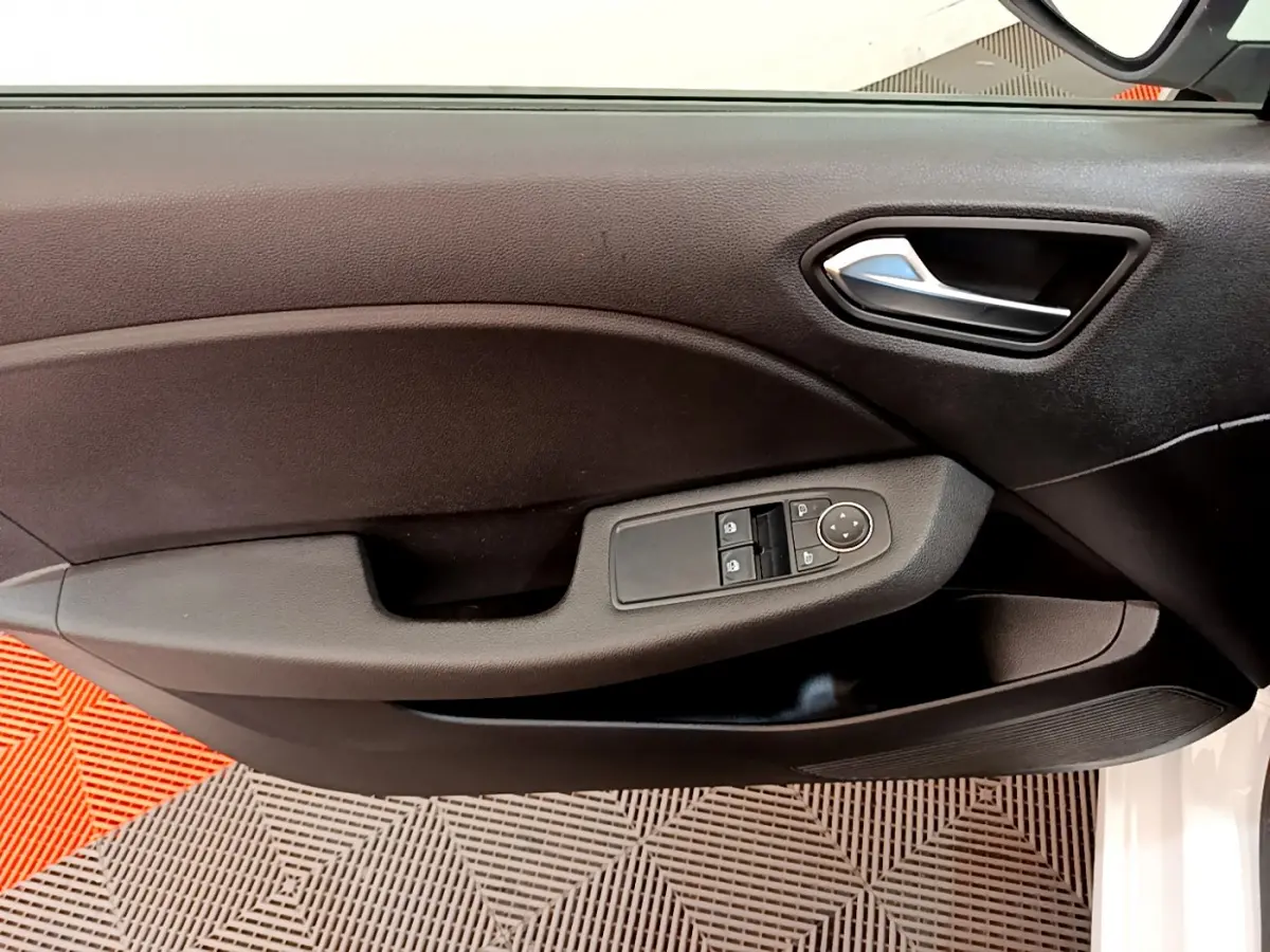 Vue rapprochée de la porte avant gauche noire de la Renault Clio Business blanche, avec commandes électriques et poignée chromée.