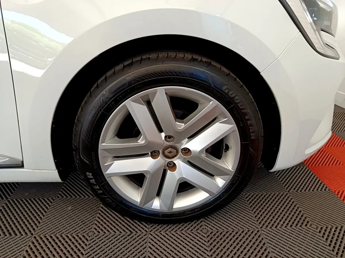 Gros plan sur la roue avant gauche d'une Renault Clio Business blanche, jante alliage et pneu Goodyear visible.