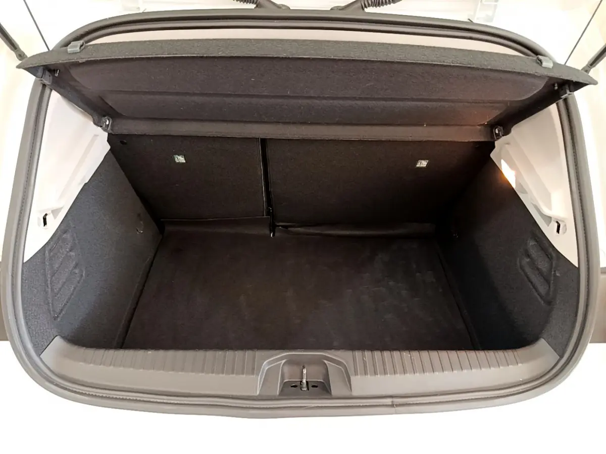 Coffre ouvert vu de l'arrière d'une Renault Clio Business blanche, montrant l'espace de chargement vide et la tablette de séparation.
