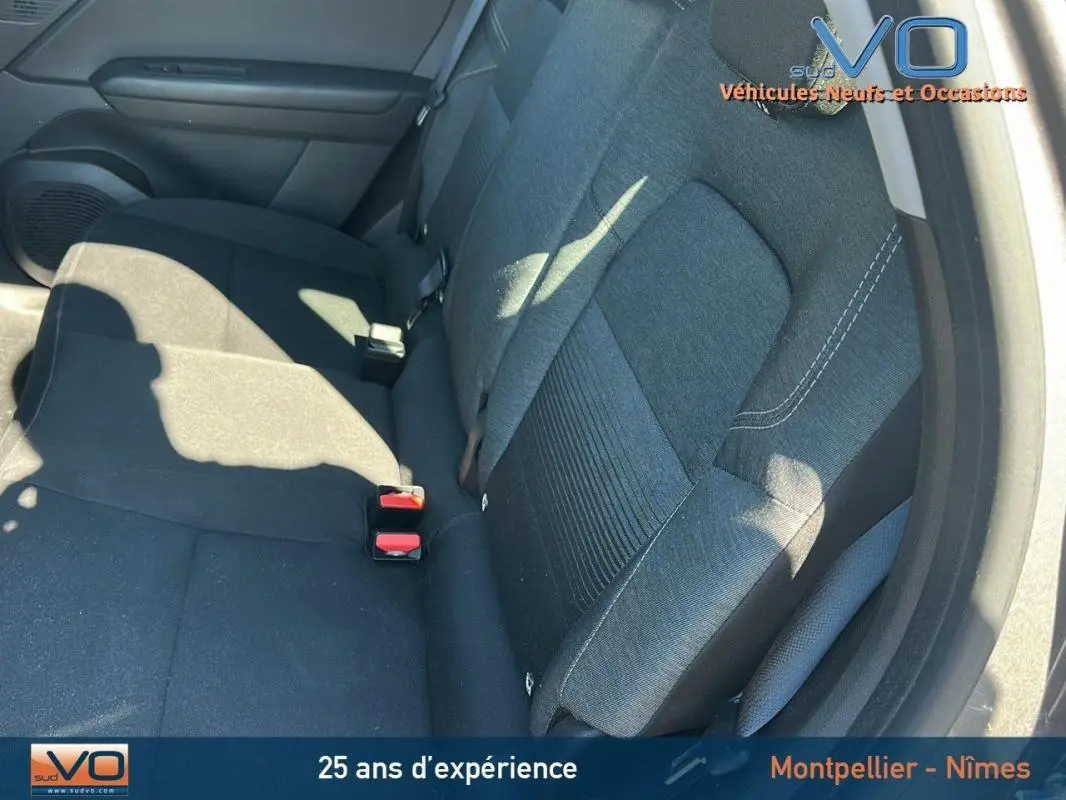 Vue intérieure du siège arrière droit gris du Renault Captur TCe 90 Business 2021 avec ceintures et porte ouvert.