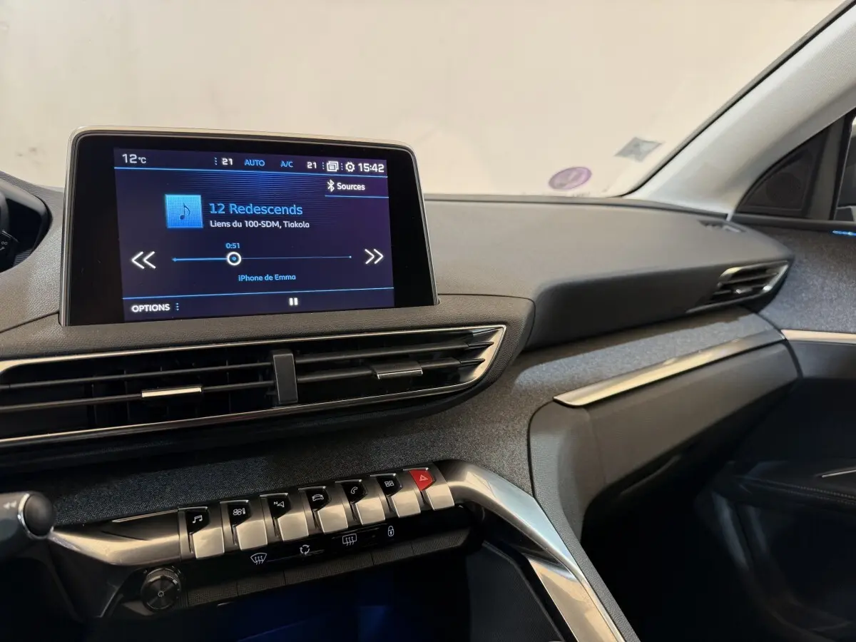 Vue intérieure côté passager du tableau de bord du Peugeot 5008 bleu avec écran tactile et commandes piano.