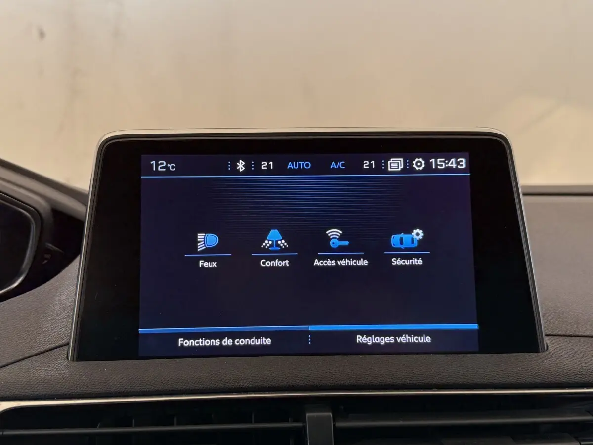 Écran tactile central du Peugeot 5008 bleu, affichant les réglages véhicule en intérieur, vue frontale rapprochée.
