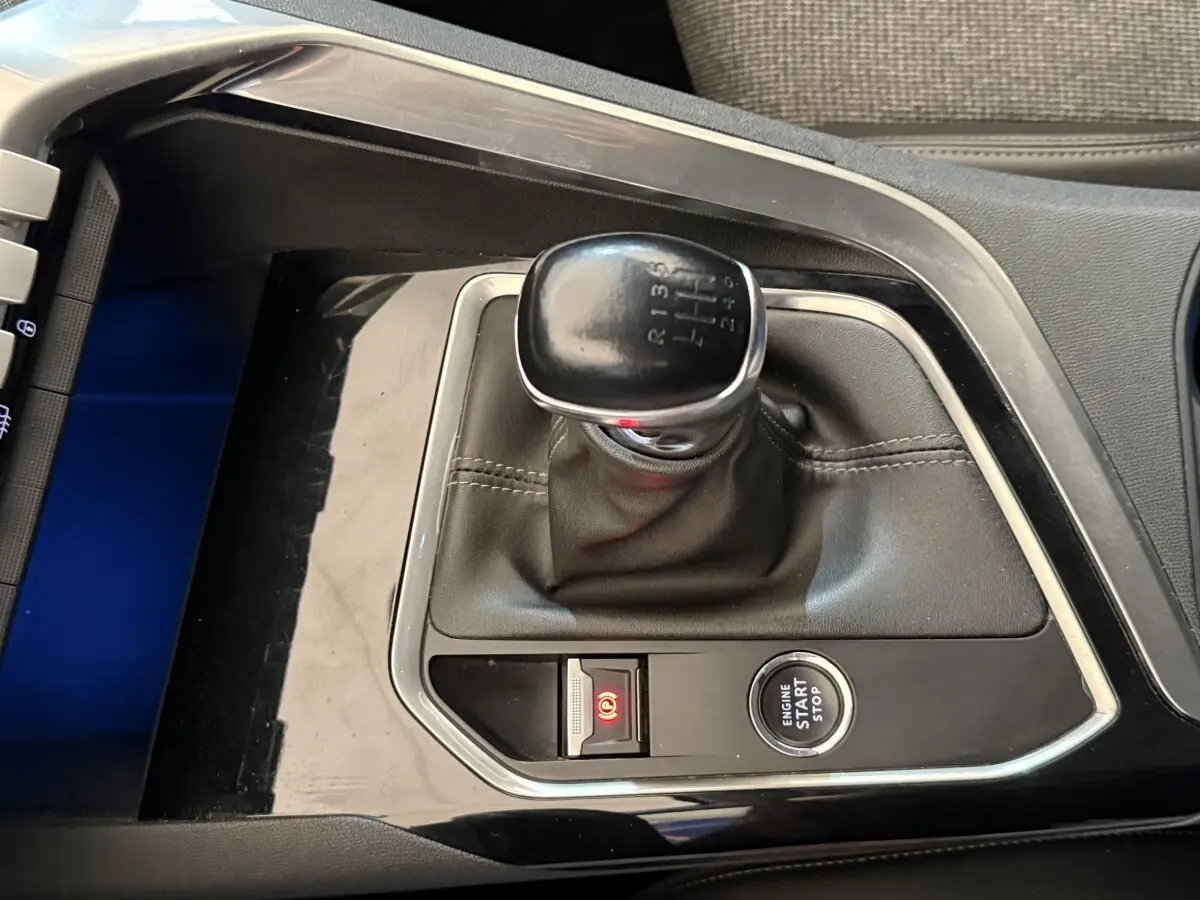 Vue rapprochée de la console centrale avec levier de vitesse manuel noir et bouton démarrage Peugeot 5008 bleu.