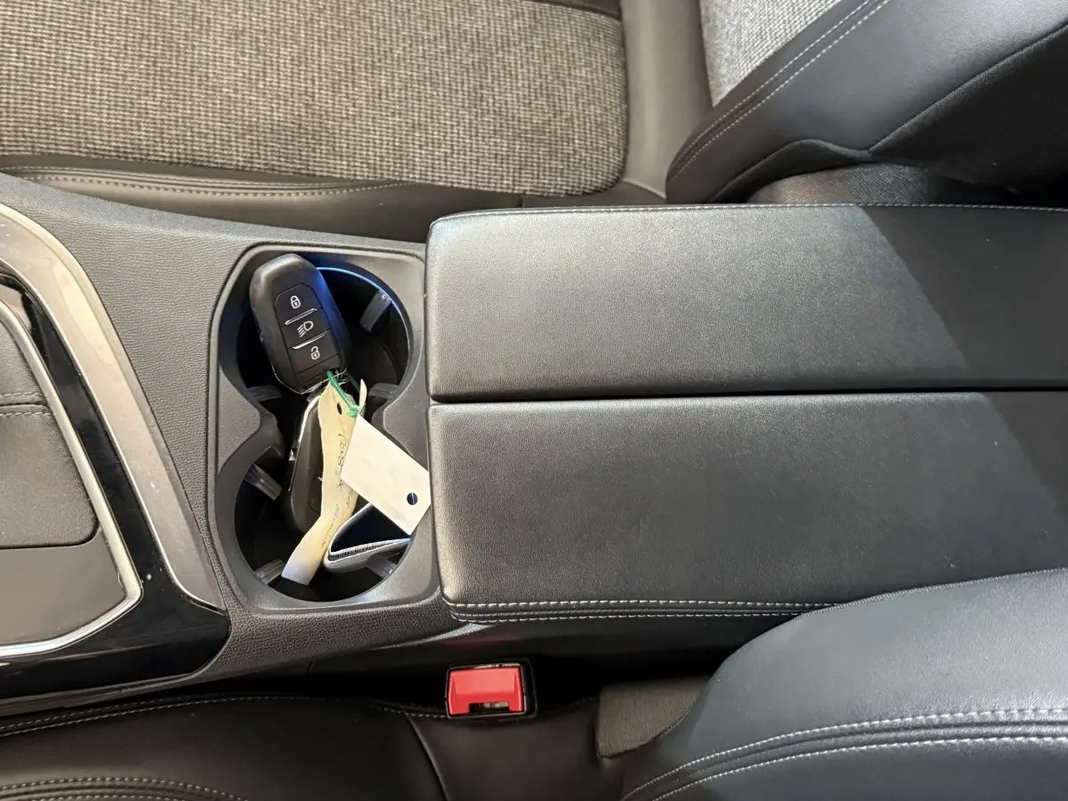 Gros plan sur la console centrale noire avec porte-gobelets contenant la clé de la Peugeot 5008 Puretech 130 S&S Allure.