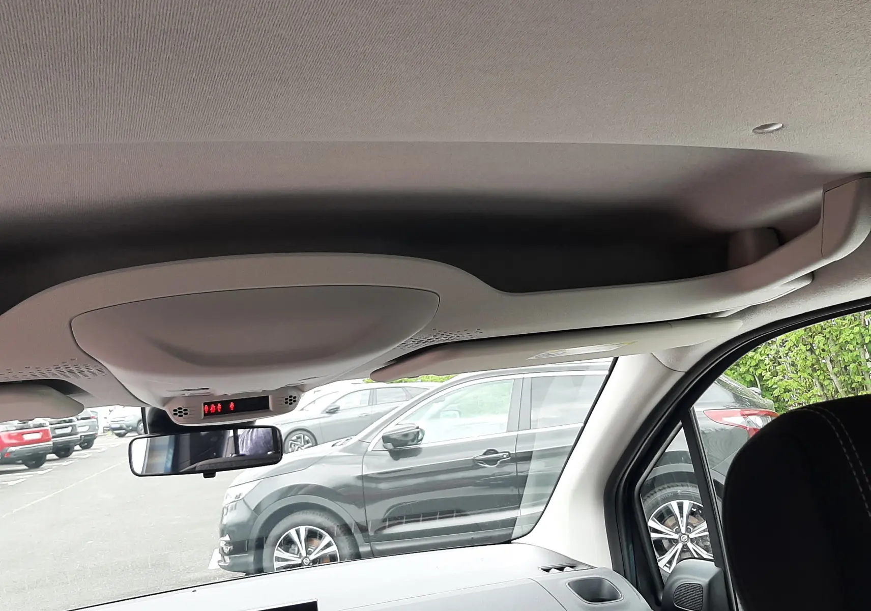 Vue intérieure avant du Peugeot Rifter bleu Kiama, montrant le tableau de bord avec écran tactile et caméra de recul activée.