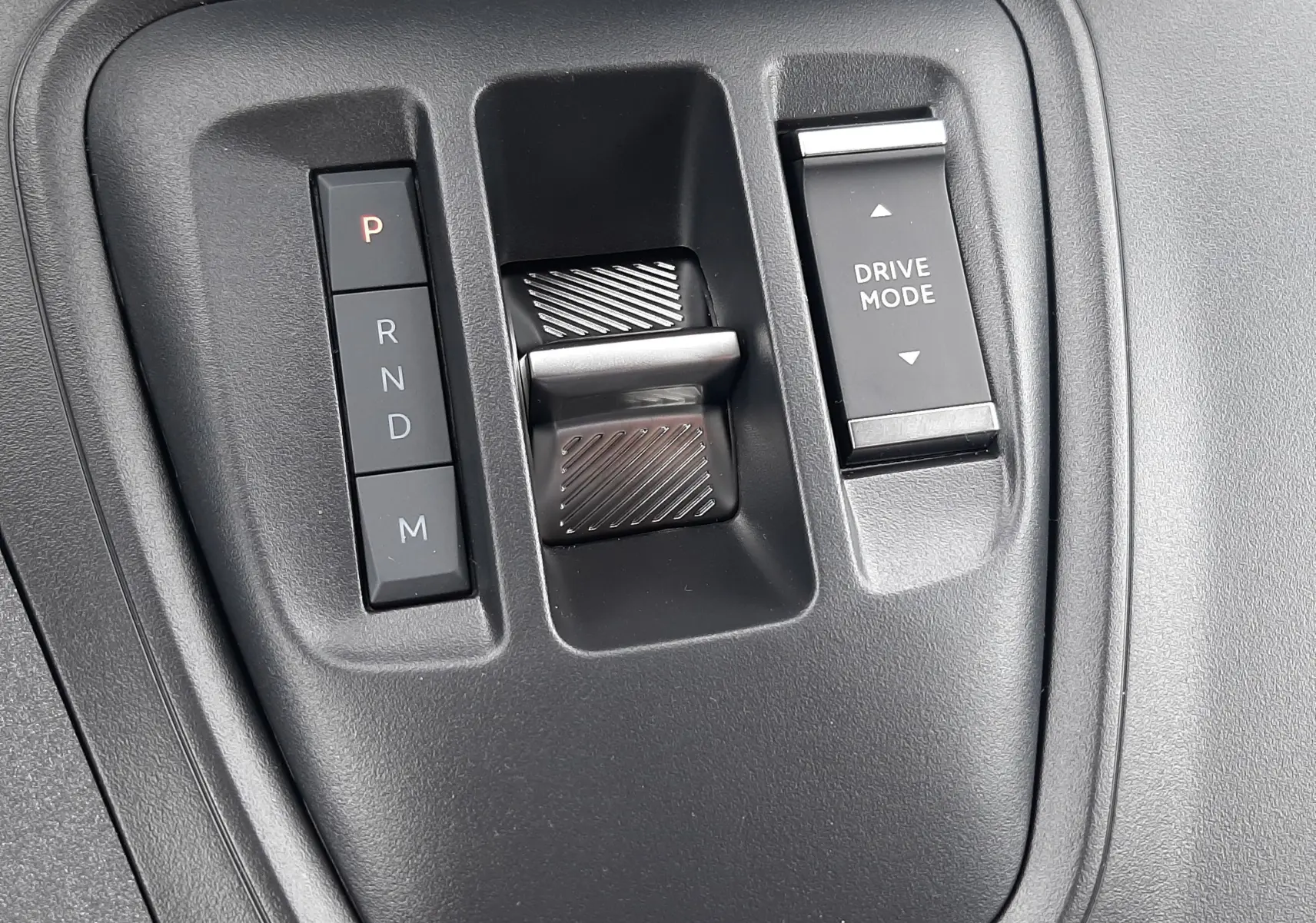 Gros plan sur la console centrale du Peugeot Rifter 2026, montrant la commande de boîte auto et le bouton Drive Mode.