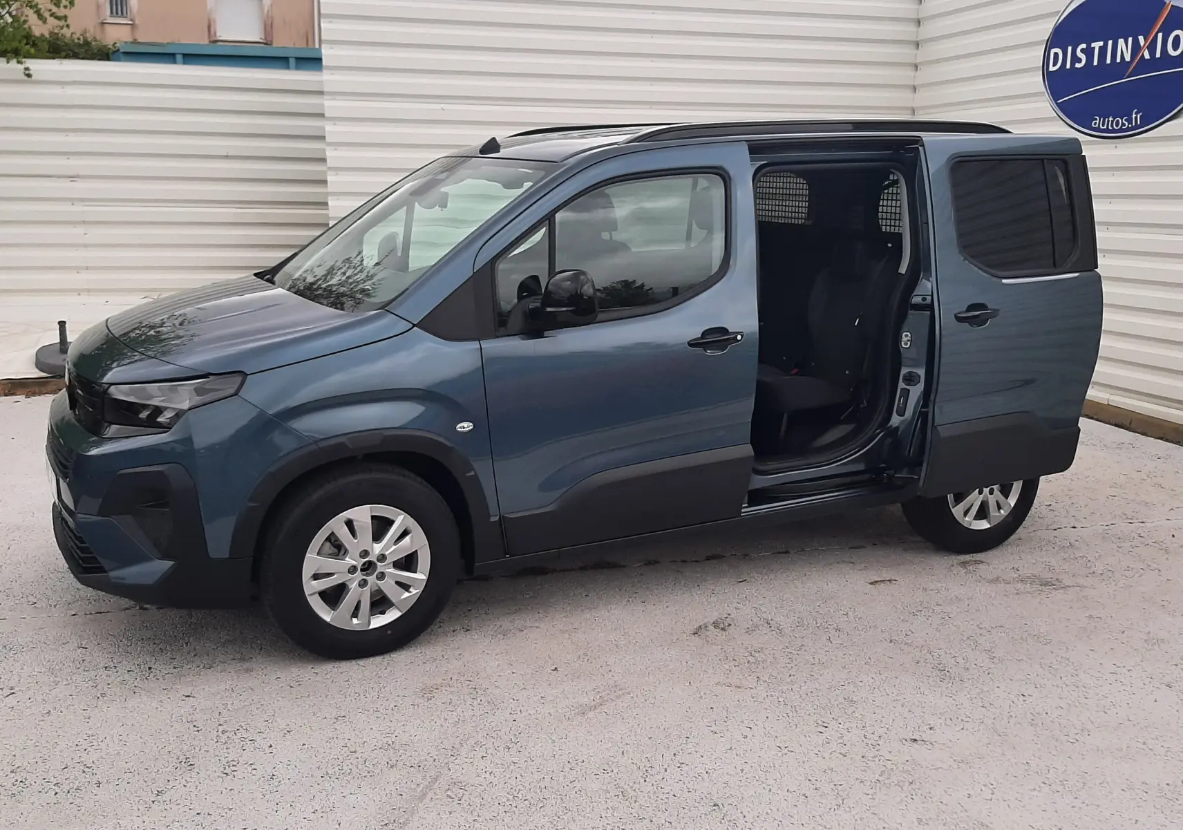 Peugeot Rifter bleu Kiama vue de profil droit avec porte coulissante arrière ouverte, intérieur visible.