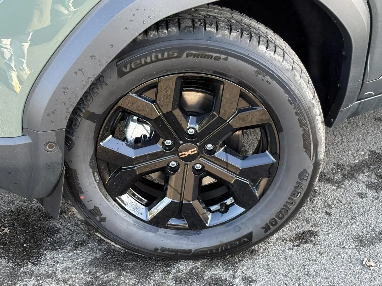 Gros plan sur la jante alliage noire 17 pouces du Dacia Duster kaki, avec pneu Hankook visible côté avant droit.