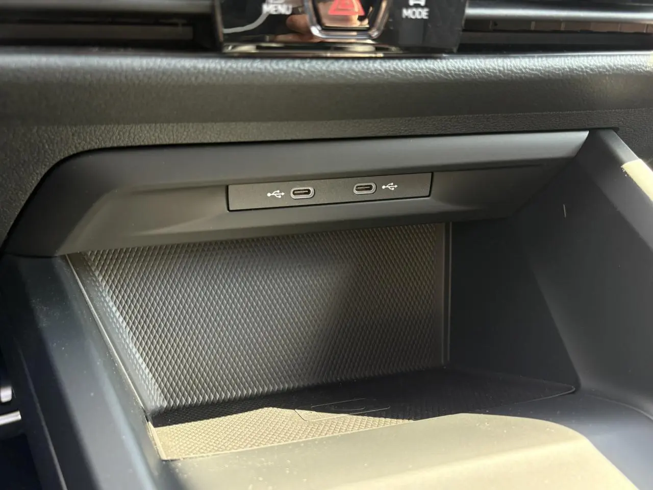 Gros plan sur la console centrale de la Volkswagen Golf VIII 1.5 TSI 2024 avec ports USB-C doubles et surface texturée noire.