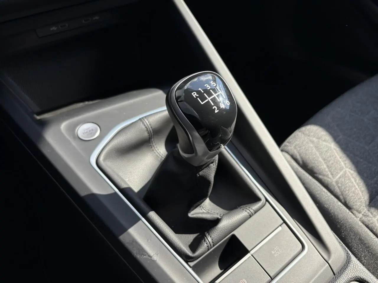 Le levier de vitesses manuel noir de la Volkswagen Golf VIII 1.5 TSI 150 Active, vu en gros plan côté console centrale.