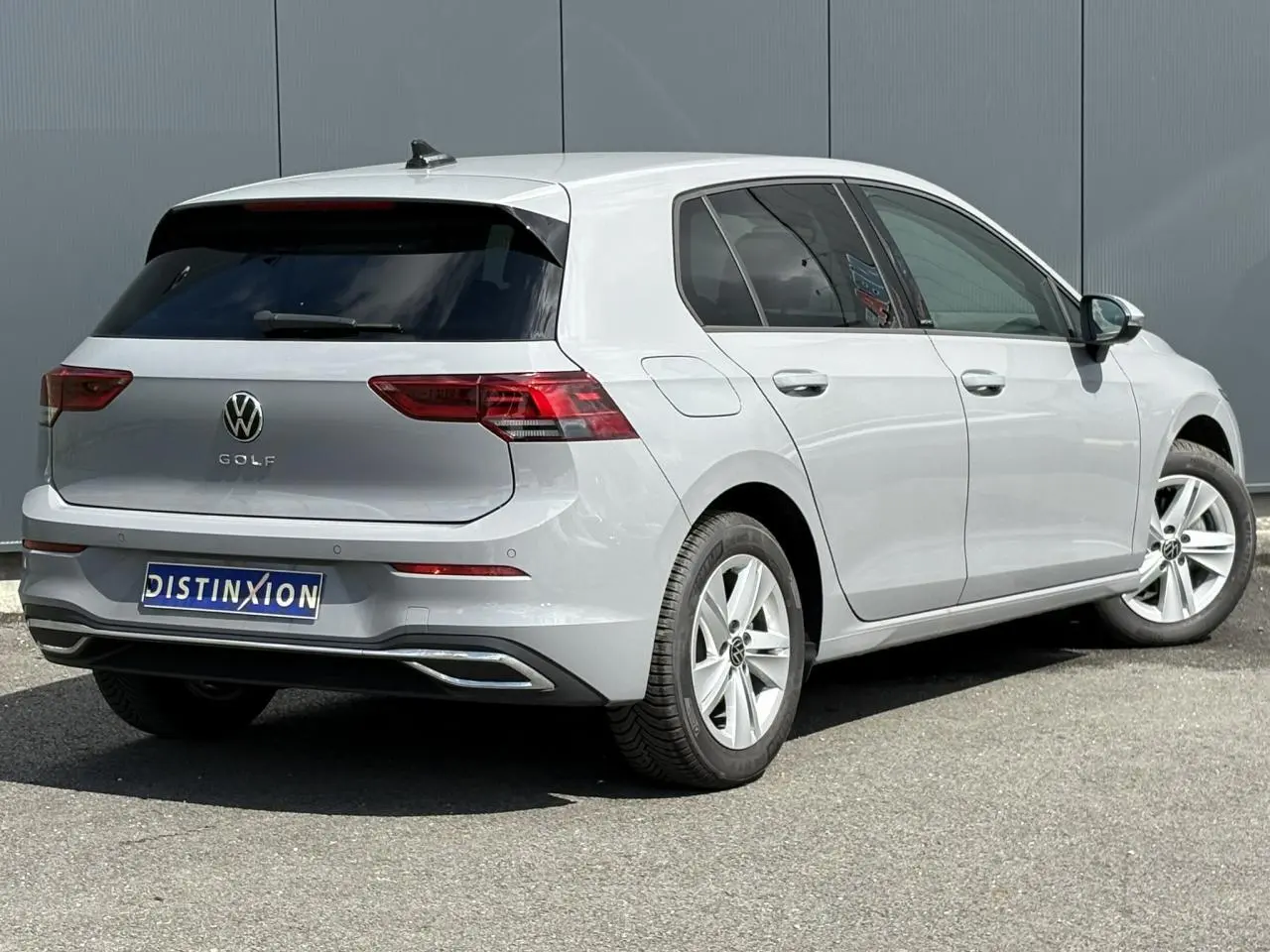 Volkswagen Golf VIII 1.5 TSI gris lunaire vue 3/4 arrière droit avec feux arrière LED et jantes alliage 16 pouces.