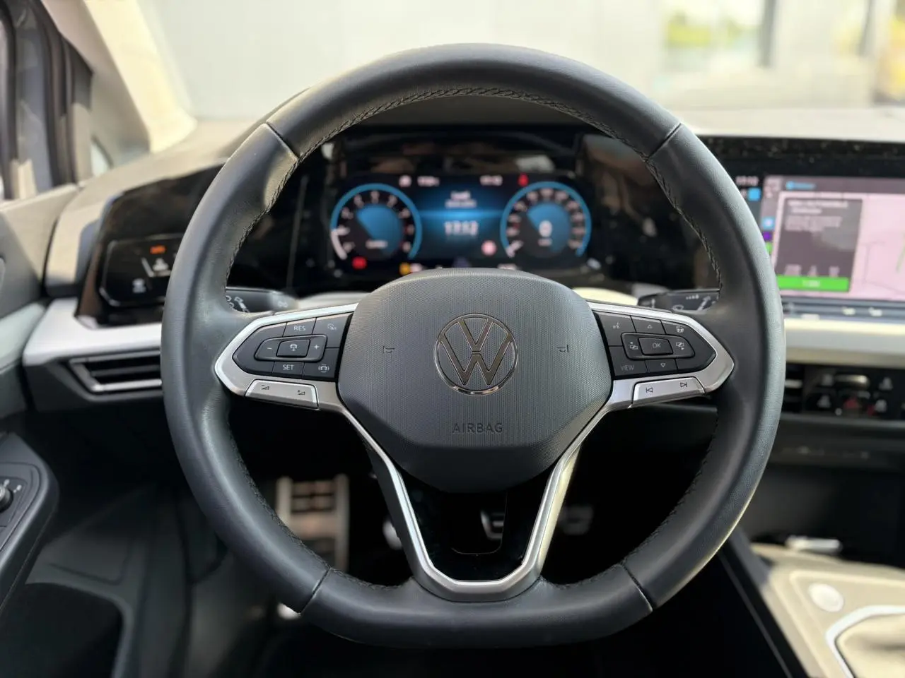 Volant cuir multifonction de Volkswagen Golf VIII 1.5 TSI 2024 avec tableau de bord digital et écran tactile visible.