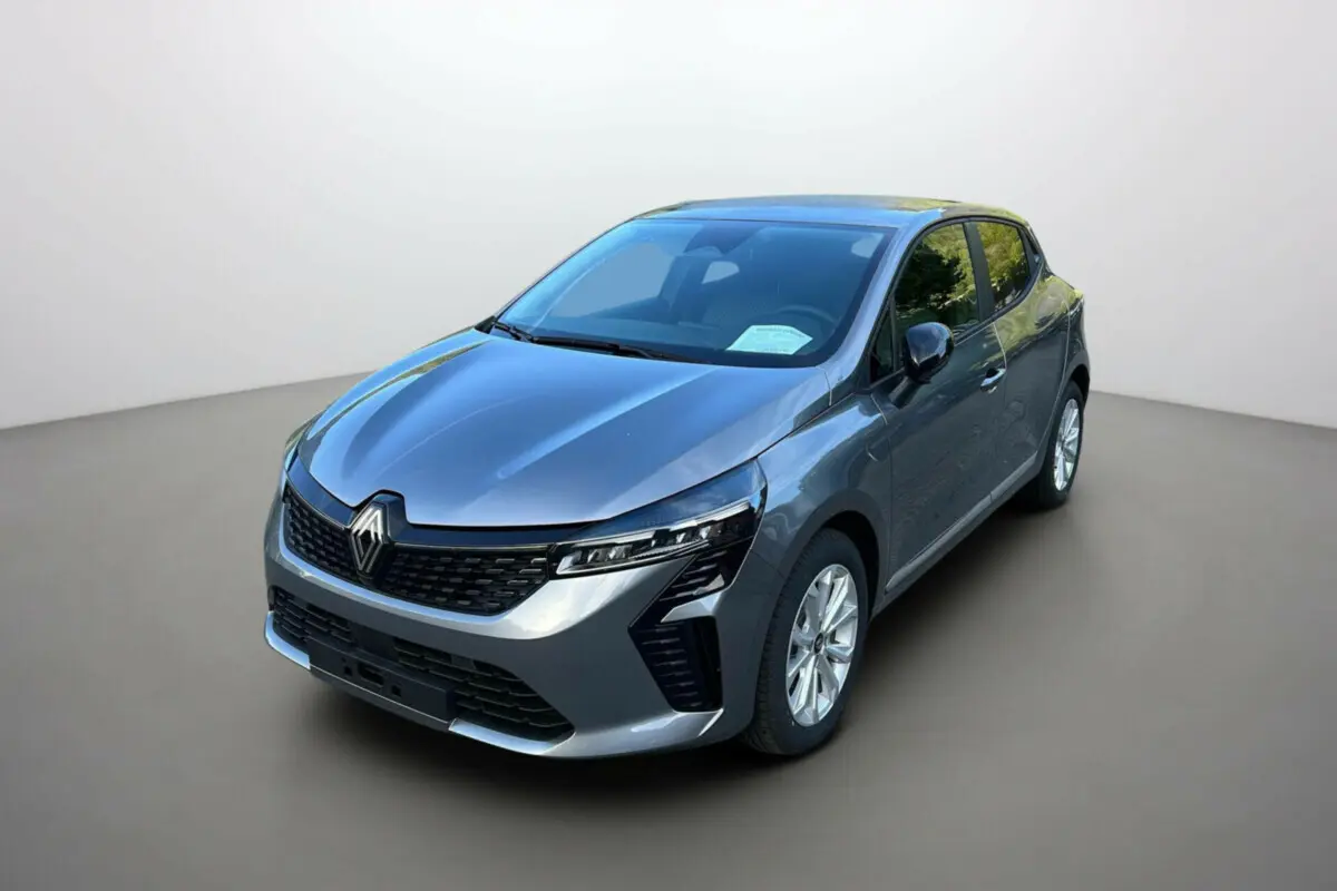 Renault Clio 2025 gris schiste vue 3/4 avant droit, avec calandre noire et feux LED fins distinctifs.