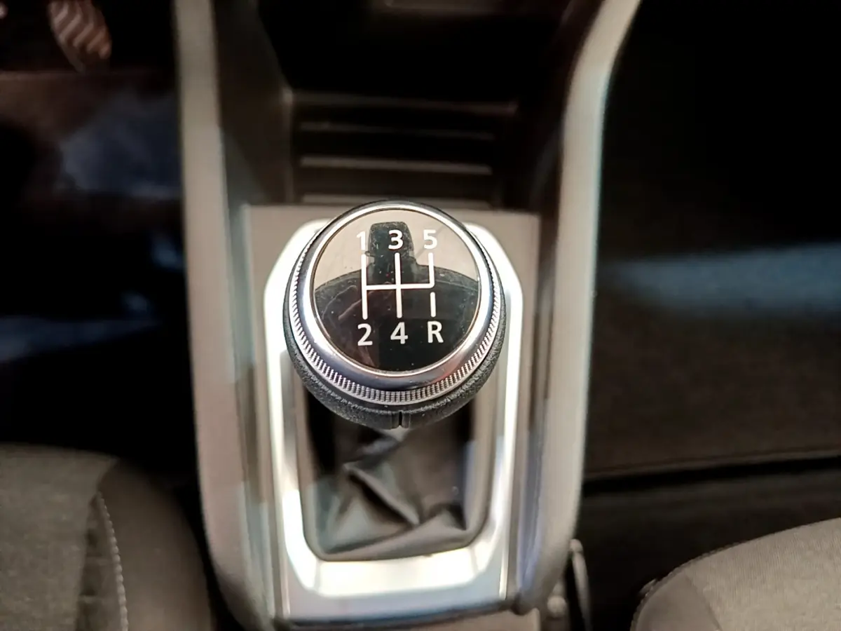 Gros plan sur le levier de vitesses manuel noir de la Renault Clio Business blanche, avec console centrale grise visible.