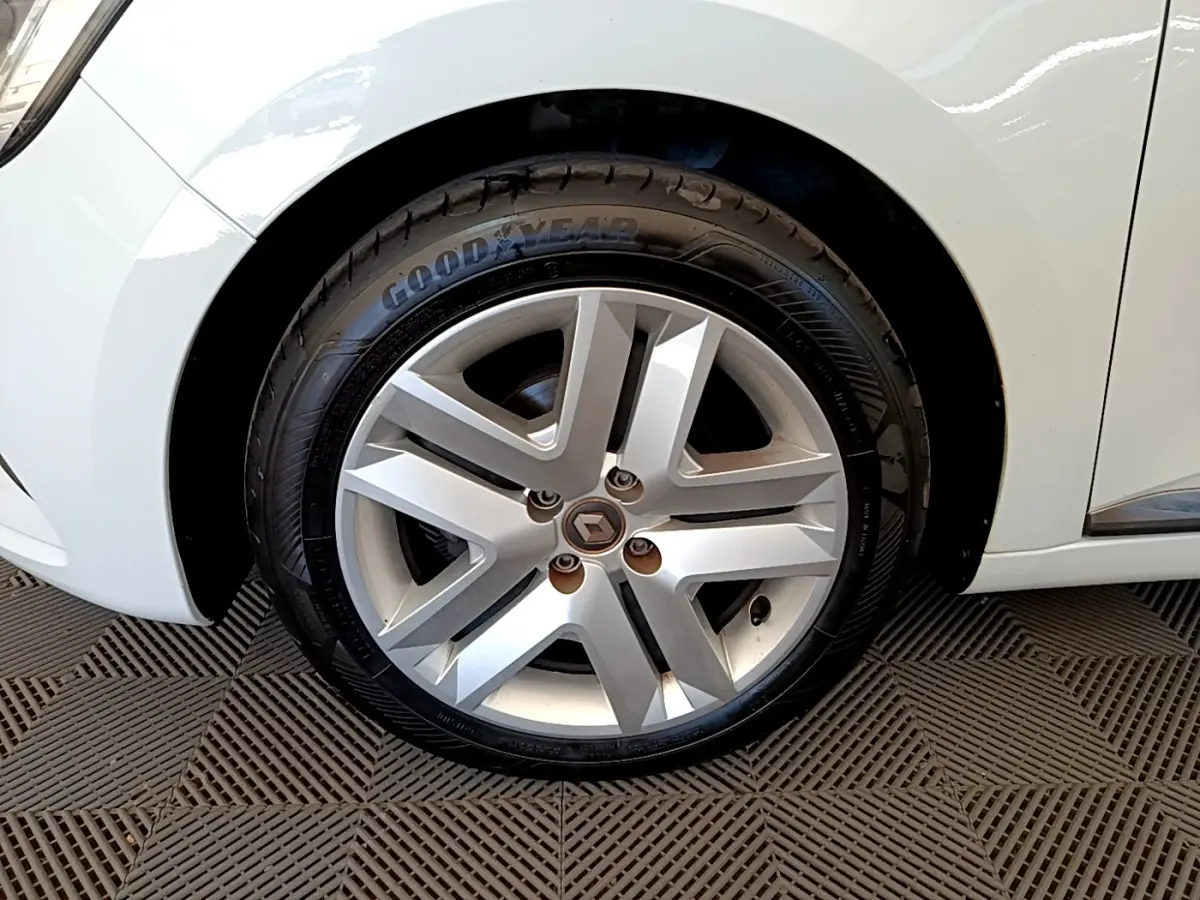 Gros plan sur la roue avant gauche de la Renault Clio Business blanche, mettant en valeur la jante alliage et le pneu Goodyear.