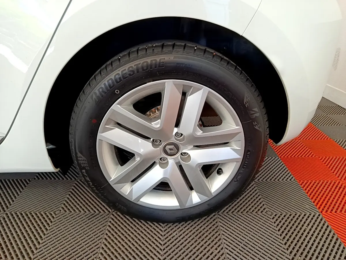 Gros plan sur la roue arrière droite blanche d'une Renault Clio Business 2021 avec jante alliage et pneu Bridgestone.