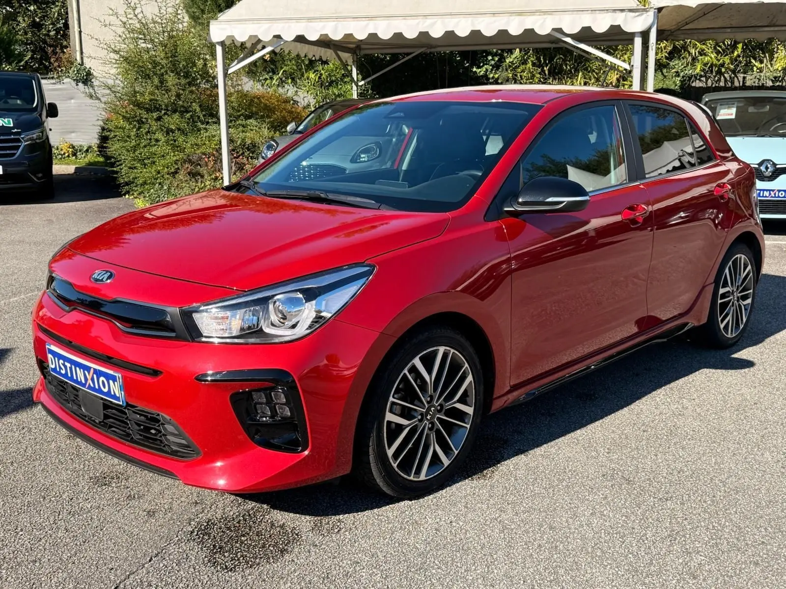 KIA Rio rouge grenadine vue 3/4 avant droit, mettant en valeur ses jantes alliage et son design dynamique.