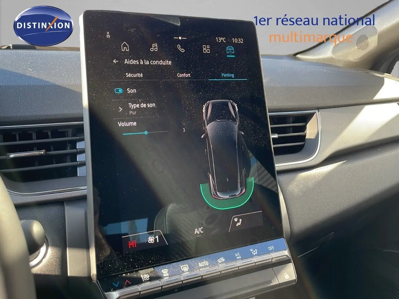Vue rapprochée de l'écran tactile central du Renault Captur E-Tech gris rafale, affichant les aides à la conduite et le parking assisté.