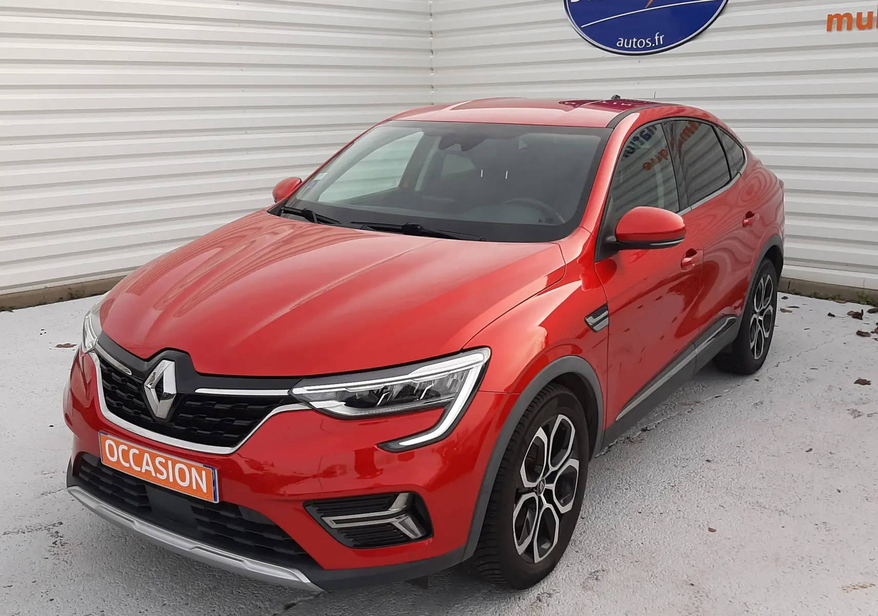 Renault Arkana rouge Flame en 3/4 avant droit, avec calandre noire et jantes alliage distinctives.