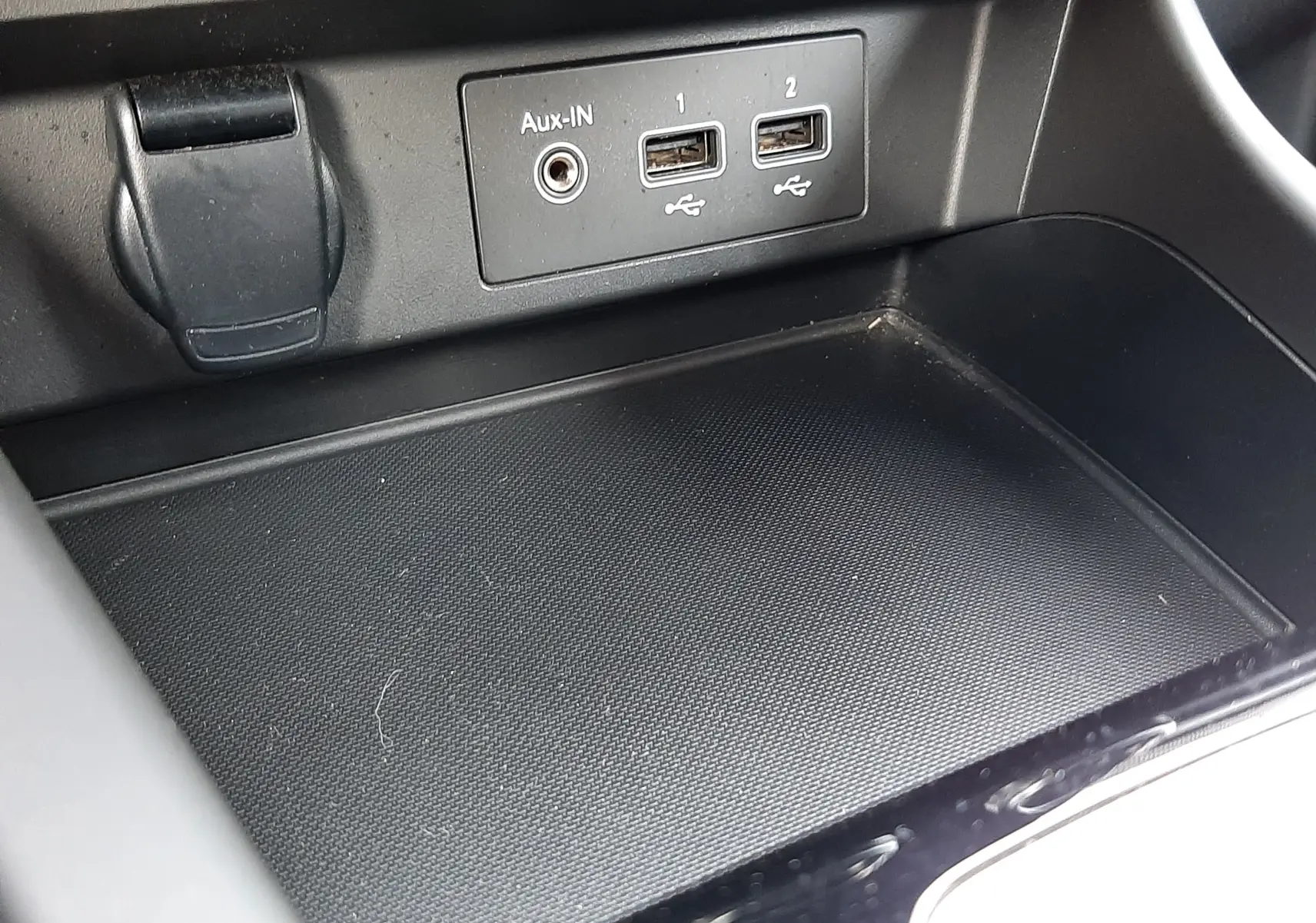 Gros plan sur la console centrale du Renault Arkana 1.6 E-TECH 145 Intens, montrant les ports USB et l'entrée Aux-In.