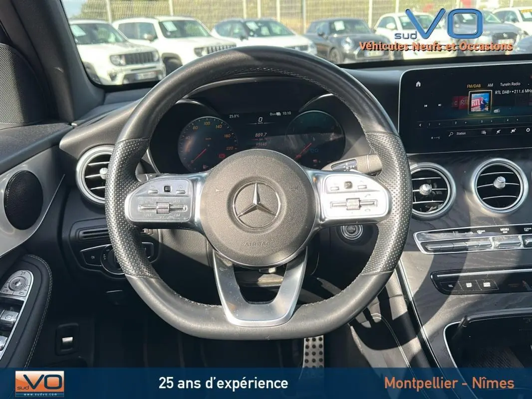 Vue intérieure centrée sur le volant sport Mercedes GLC 300 de gris anthracite avec tableau de bord numérique et écran tactile.
