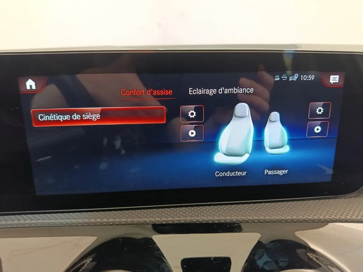 Écran tactile intérieur de la Mercedes Classe A blanc, affichant les réglages de confort d’assise et éclairage d’ambiance.