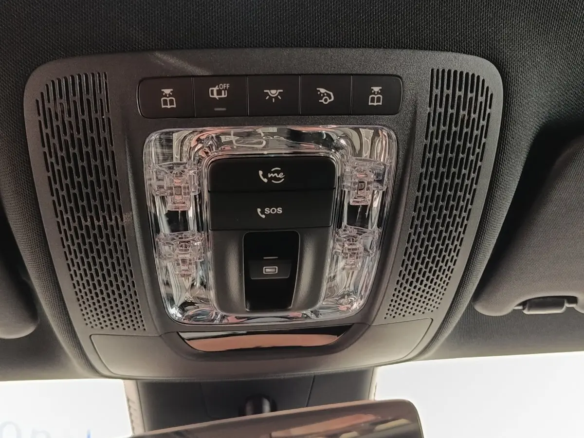 Vue en plongée sur le plafonnier intérieur noir avec commandes SOS et éclairage d'une Mercedes Classe A blanche.