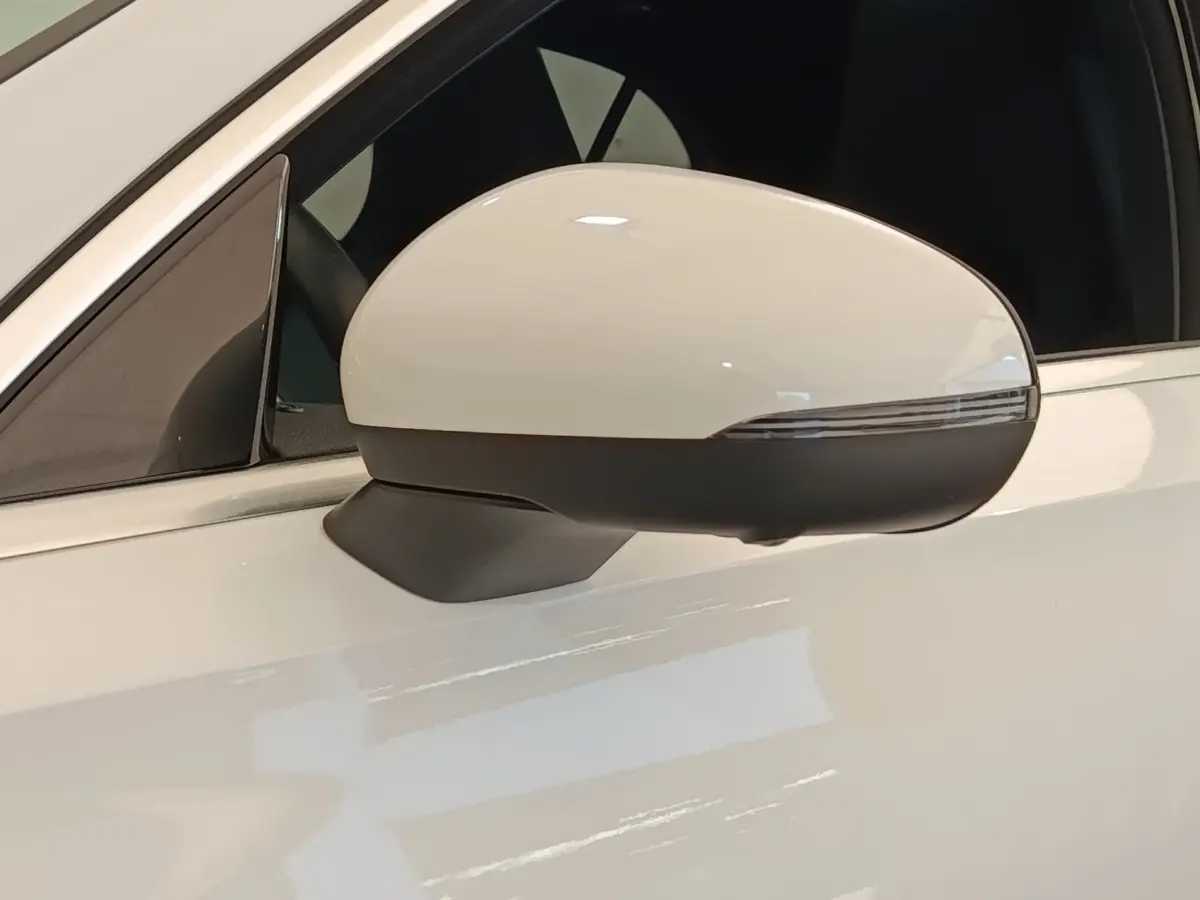 Gros plan sur le rétroviseur droit blanc et noir d’une Mercedes Classe A 250 e AMG Line 2021 hybride rechargeable.