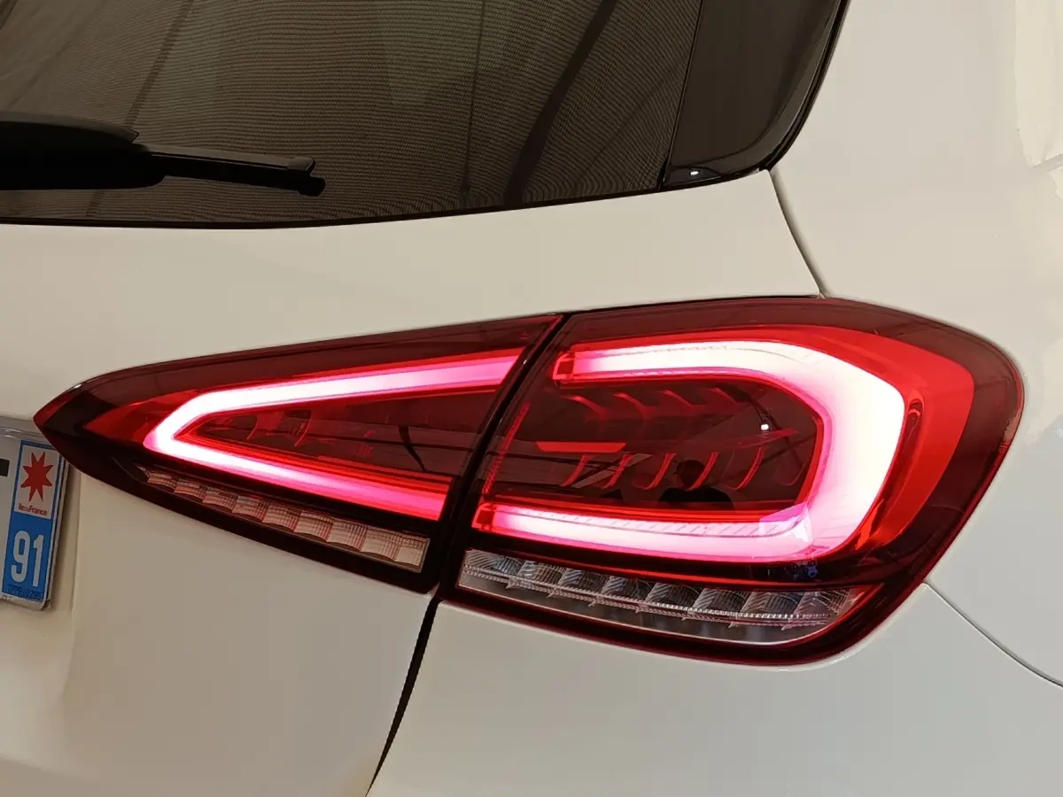 Gros plan sur le feu arrière droit allumé d'une Mercedes Classe A 250 e AMG Line blanche de 2021.