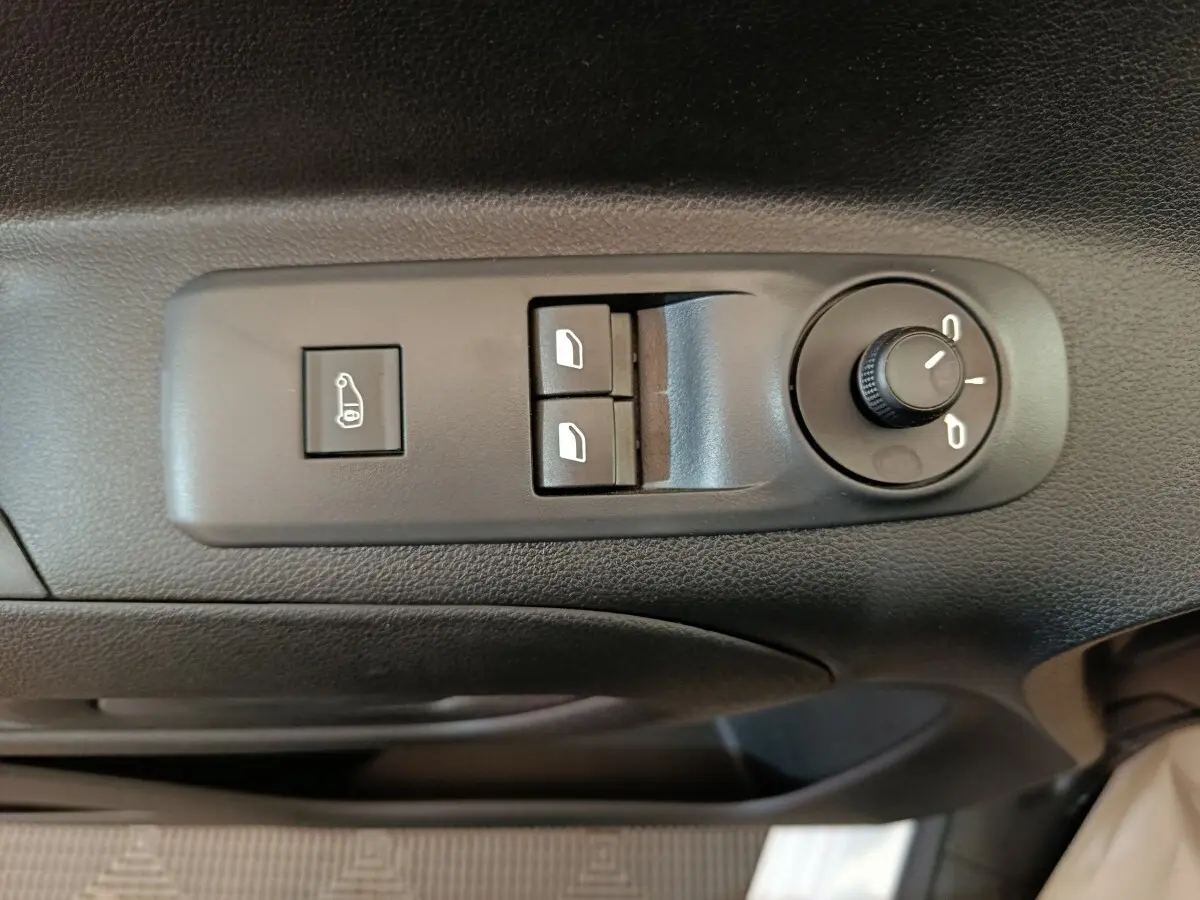 Gros plan sur les commandes de réglage des rétroviseurs et des vitres côté conducteur du Peugeot Partner blanc 2026.