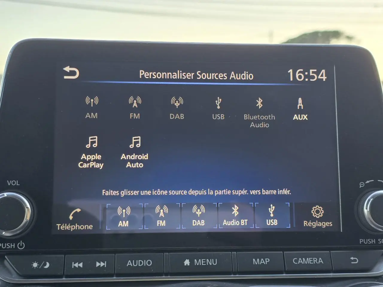 Écran tactile du système audio du Nissan Juke II bleu magnetic, affichant les options de sources audio.