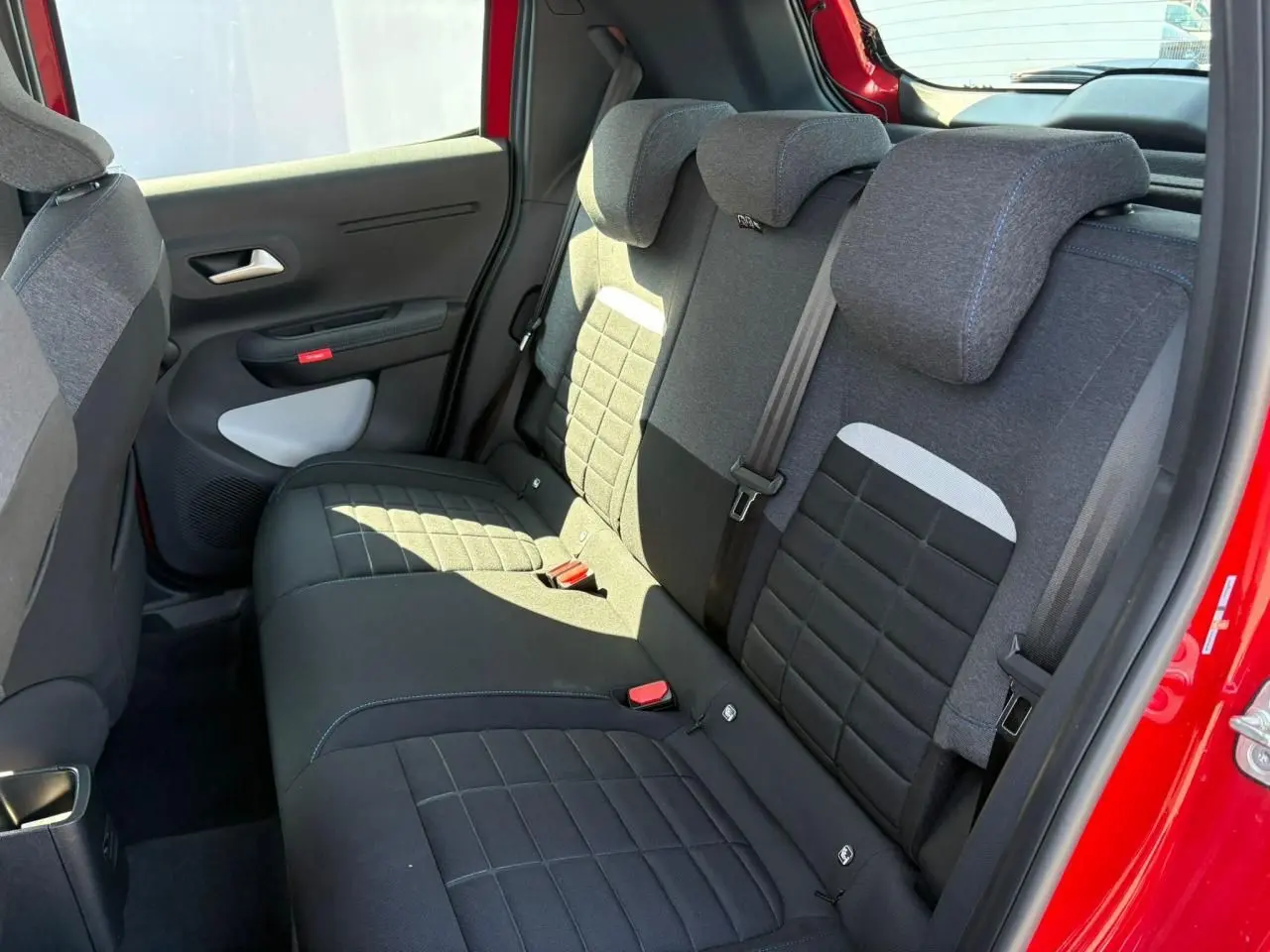 Banquette arrière en tissu gris et noir vue côté gauche d'une Citroën C3 Rouge Elixir avec porte ouverte.