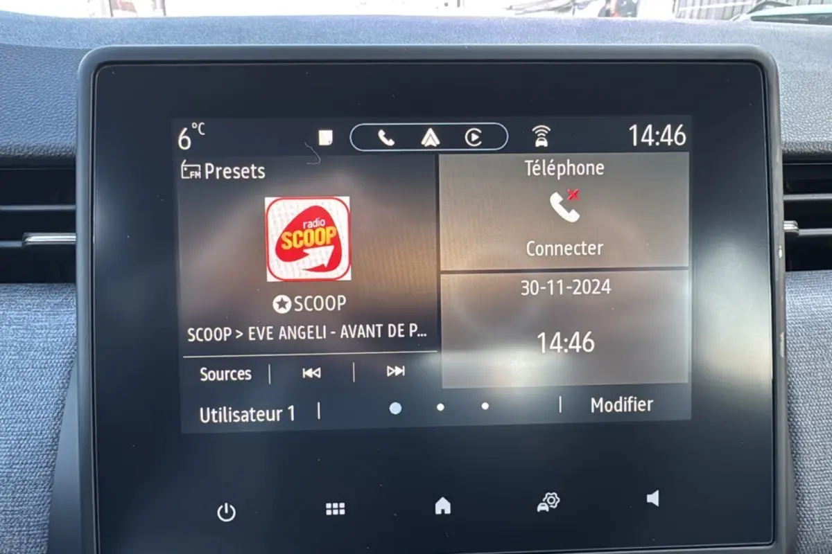Écran tactile central de la Renault Clio 2025 affichant la radio et la connexion téléphone, intérieur noir.